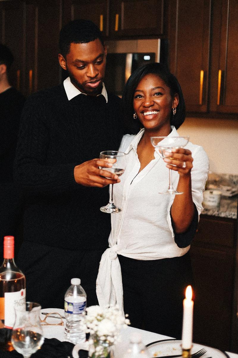 Un homme et une femme lèvent leur verre en souriant